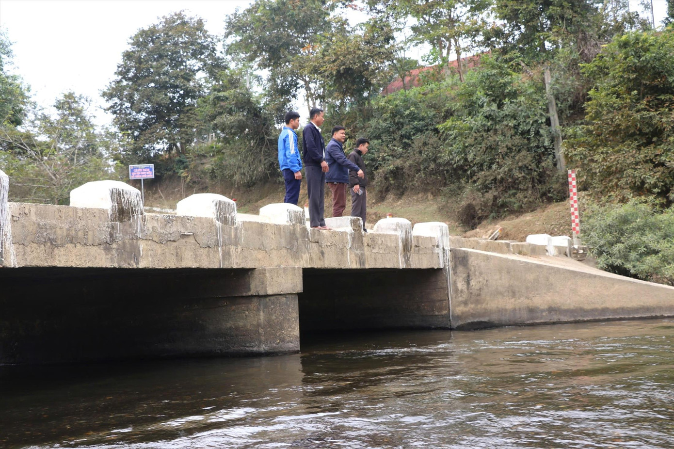 Ông Thanh cùng lãnh đạo xã Châu Phong và cán bộ bản Lìm tại cầu tràn, nơi xảy ra nhiều tình huống nguy hiểm trong mùa mưa lũ