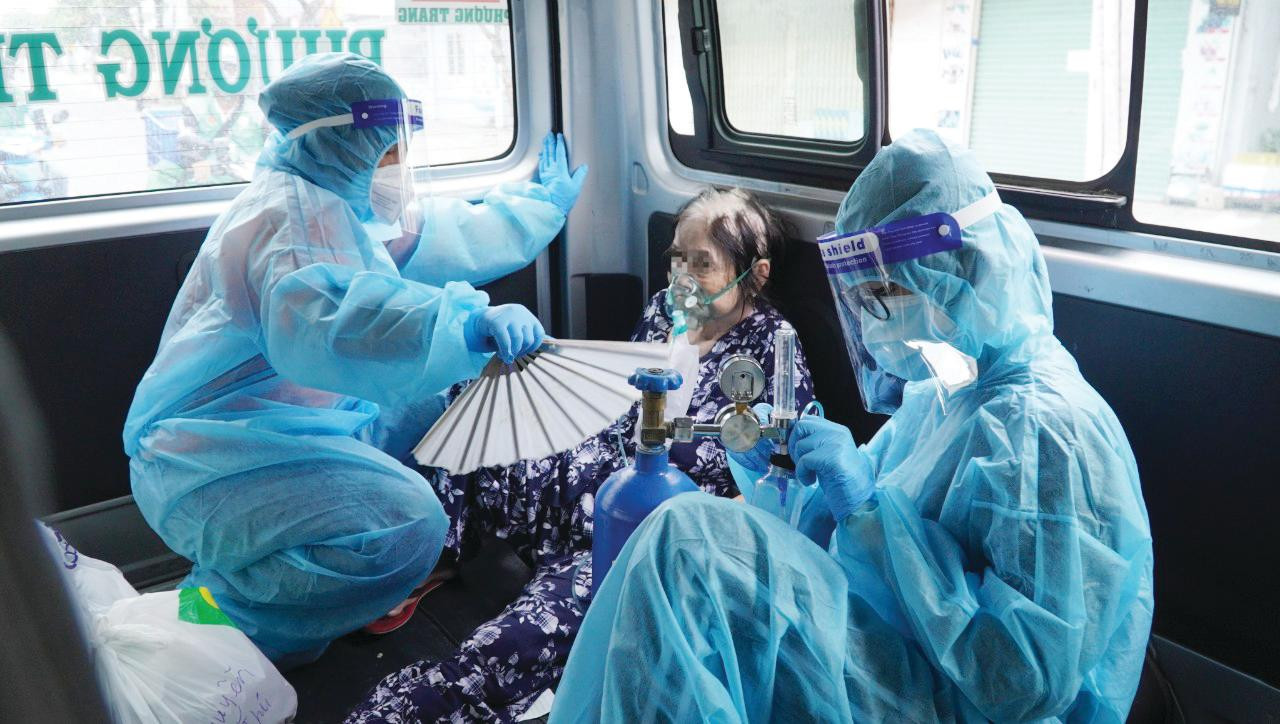 Hai nữ tình nguyện viên chăm sóc một bà cụ F0 trên xe cấp cứu Hai nữ tình nguyện viên chăm sóc một bà cụ F0 trên xe cấp cứu