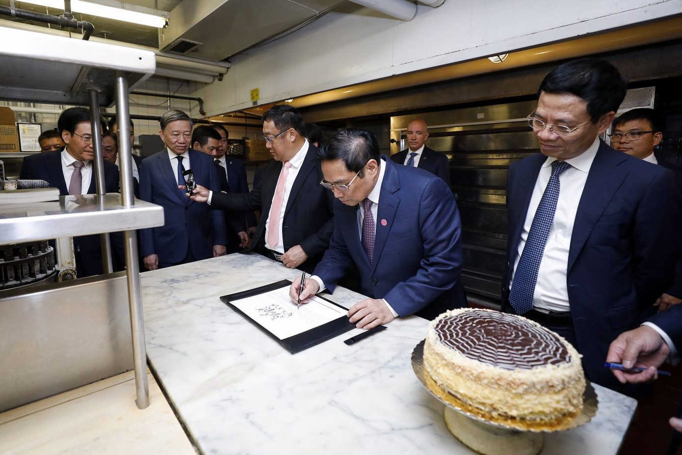 Thủ tướng Phạm Minh Chính ghi cảm tưởng ngay tại chiếc bàn Bác Hồ từng làm bánh tại khách sạn Omni Parker House ngày 14/5/2022.