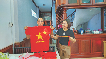 Vợ chồng anh Oanh và chị Liên (Viêng Chăn) chuẩn bị cổ vũ đội tuyển Việt Nam