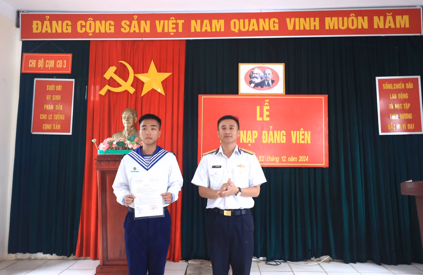 Bí thư Chi bộ, Chính trị viên Cụm chiến đấu 3, đảo Trường Sa trao quyết định kết nạp đảng viên mới cho chiến sĩ trẻ Nghiêm Công Phong (bên trái). Ảnh: Như Ý.