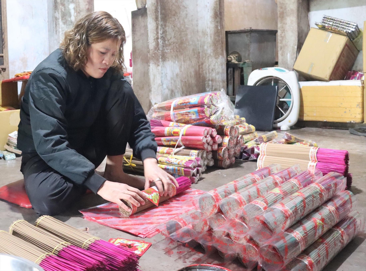 Việc đóng bì, dán nhãn cho nhang giúp chị Trần Thị Kim Trực có thu nhập trong mùa dịch bệnh. Ảnh THỤC HIỀN