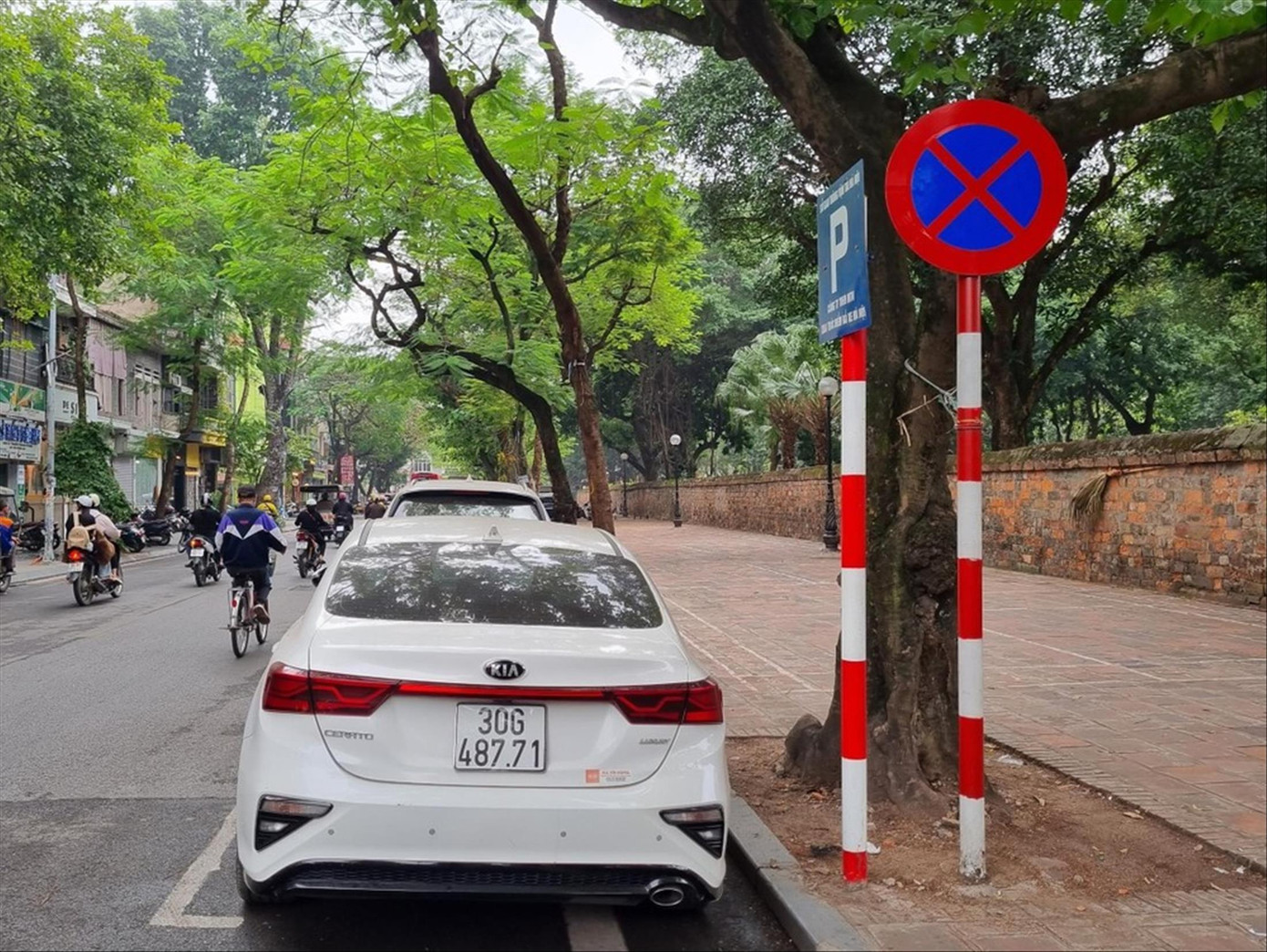 Biển báo cấm ô tô dừng đỗ được cắm ngay cạnh biển thông báo điểm trông giữ xe tại Hà Nội. Ảnh: Viết Hà