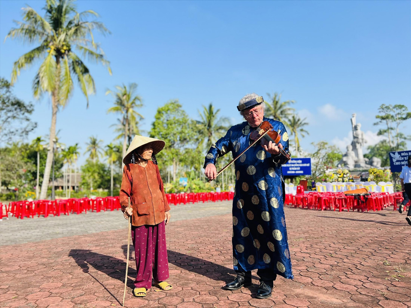 Cựu binh Mỹ Roy Mike Boehm kéo vĩ cầm tưởng niệm, bên một nạn nhân sống sót sau vụ thảm sát Ảnh: Nguyễn Ngọc Cựu binh Mỹ Roy Mike Boehm kéo vĩ cầm tưởng niệm, bên một nạn nhân sống sót sau vụ thảm sát Ảnh: Nguyễn Ngọc