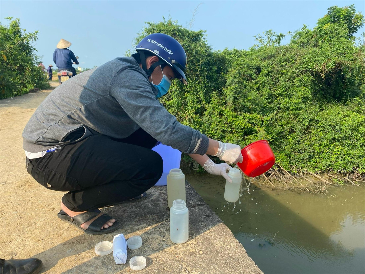 Cơ quan chức năng lấy mẫu nước tại một con kênh ở gần CCN làng nghề Tịnh Ấn Tây. Ảnh: NN Cơ quan chức năng lấy mẫu nước tại một con kênh ở gần CCN làng nghề Tịnh Ấn Tây. Ảnh: NN