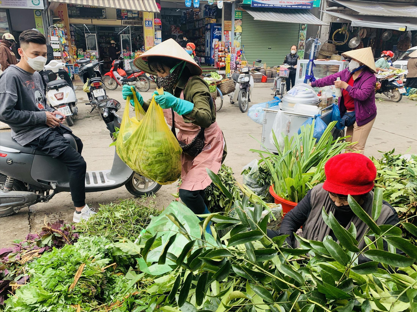 Tiểu thương chợ Giếng Vuông luôn tay bán “bó lá xông” cho khách. Ảnh: Duy Chiến Tiểu thương chợ Giếng Vuông luôn tay bán “bó lá xông” cho khách. Ảnh: Duy Chiến