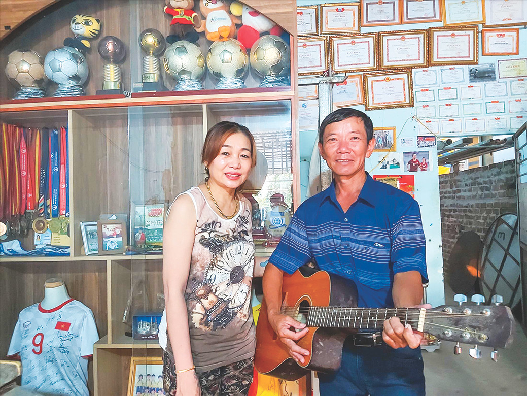 Cha mẹ Huỳnh Như bên cạnh cây đờn guitar Cha mẹ Huỳnh Như bên cạnh cây đờn guitar