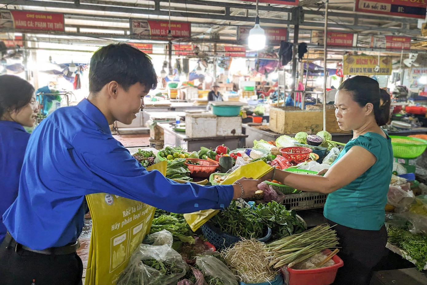 Các tình nguyện viên tặng túi sinh học cho tiểu thương tại chợ, góp phần thay đổi hành vi, tạo thói quen đi chợ “xanh” Ảnh: G.T Các tình nguyện viên tặng túi sinh học cho tiểu thương tại chợ, góp phần thay đổi hành vi, tạo thói quen đi chợ “xanh” Ảnh: G.T