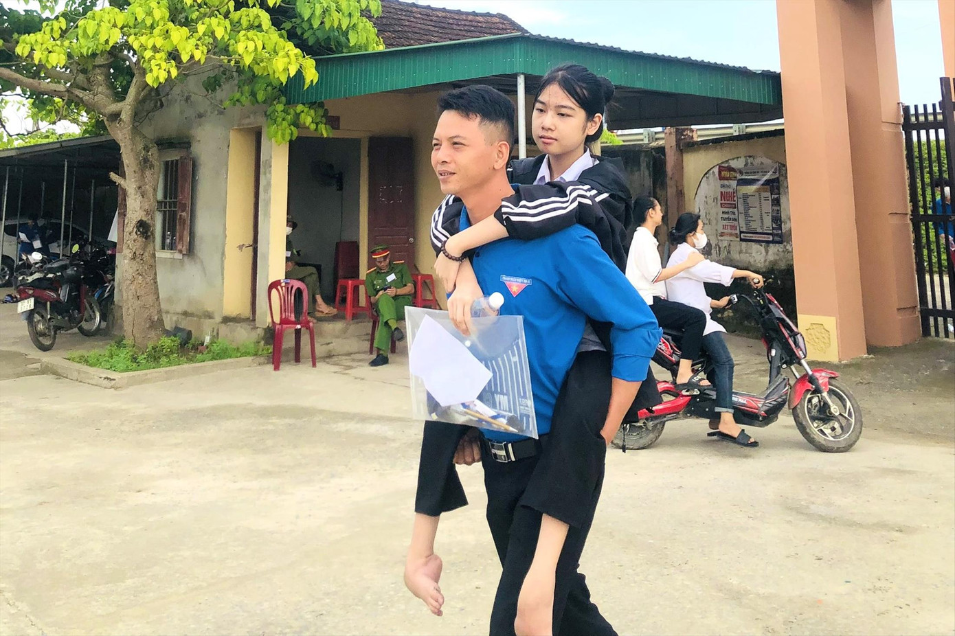 Bí thư Đoàn xã Võ Liệt Nguyễn Văn Hoàng cõng thí sinh Nguyễn Thị Hiền tới điểm thi