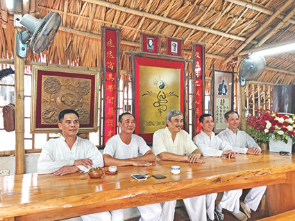 Ông Trần Việt Trung ngồi giữa các môn đệ. Ảnh: Thái An