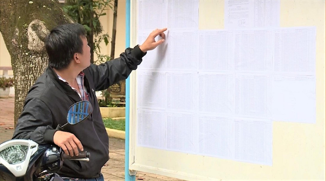 Phụ huynh đang tìm tên con mình trên bảng công bố điểm thi Phụ huynh đang tìm tên con mình trên bảng công bố điểm thi