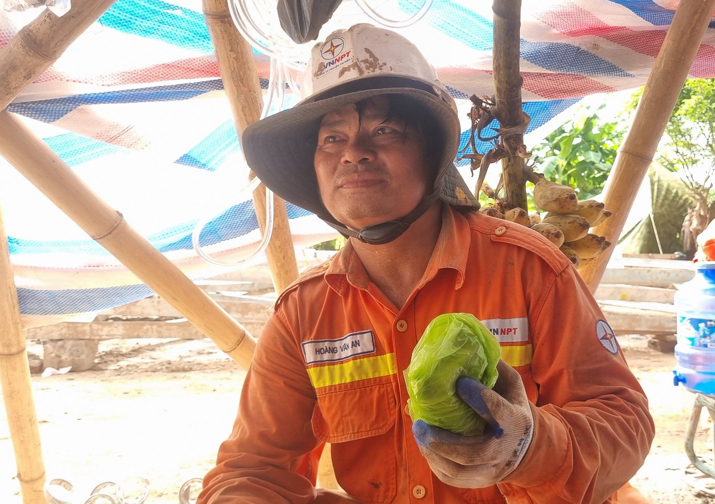 Anh Hoàng Văn An gói chiếc điện thoại của mình vào túi ni lông để tránh bị mồ hôi làm ướt, hỏng điện thoại