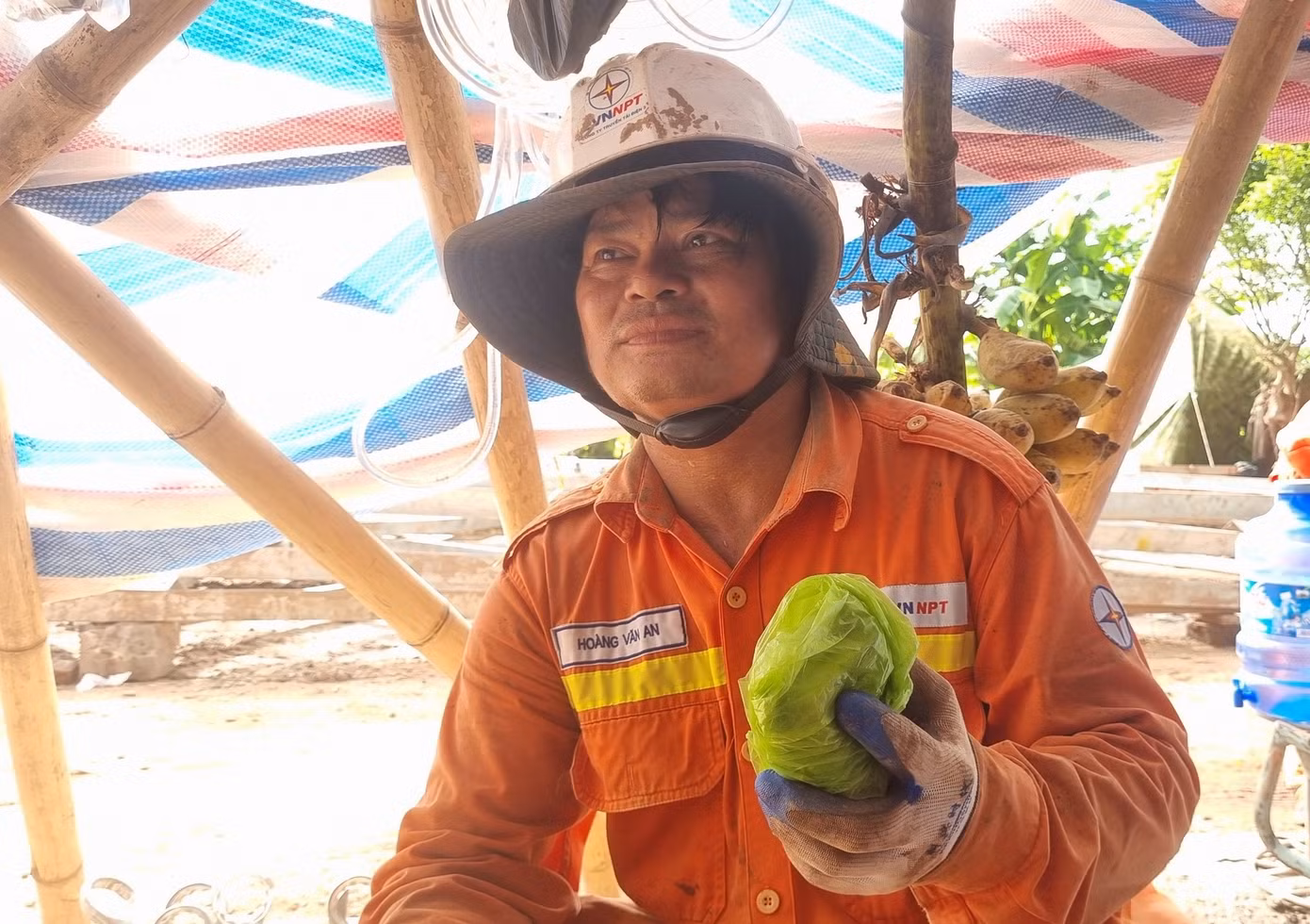 Anh Hoàng Văn An gói chiếc điện thoại của mình vào túi ni lông để tránh bị mồ hôi làm ướt, hỏng điện thoại