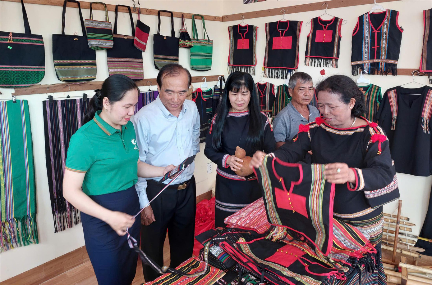 Bà H’Yam (bìa phải) giới thiệu sản phẩm thổ cẩm.