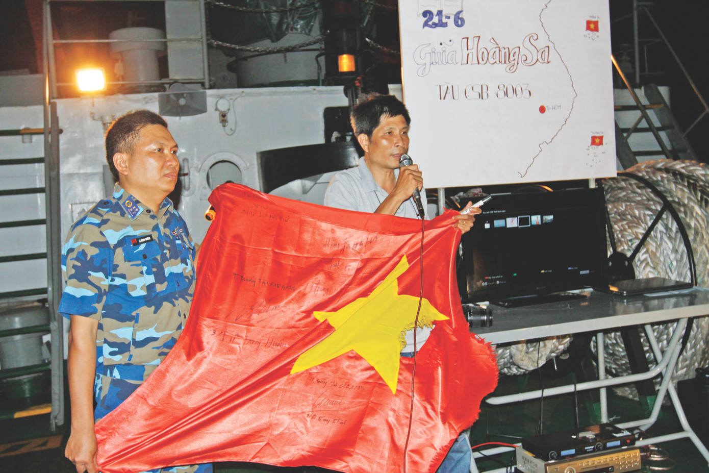 Nhà báo Trần Tuấn - áo trắng - với lá cờ Tổ quốc bị thương giữa sóng gió Hoàng Sa. Ảnh: Đức Hạnh