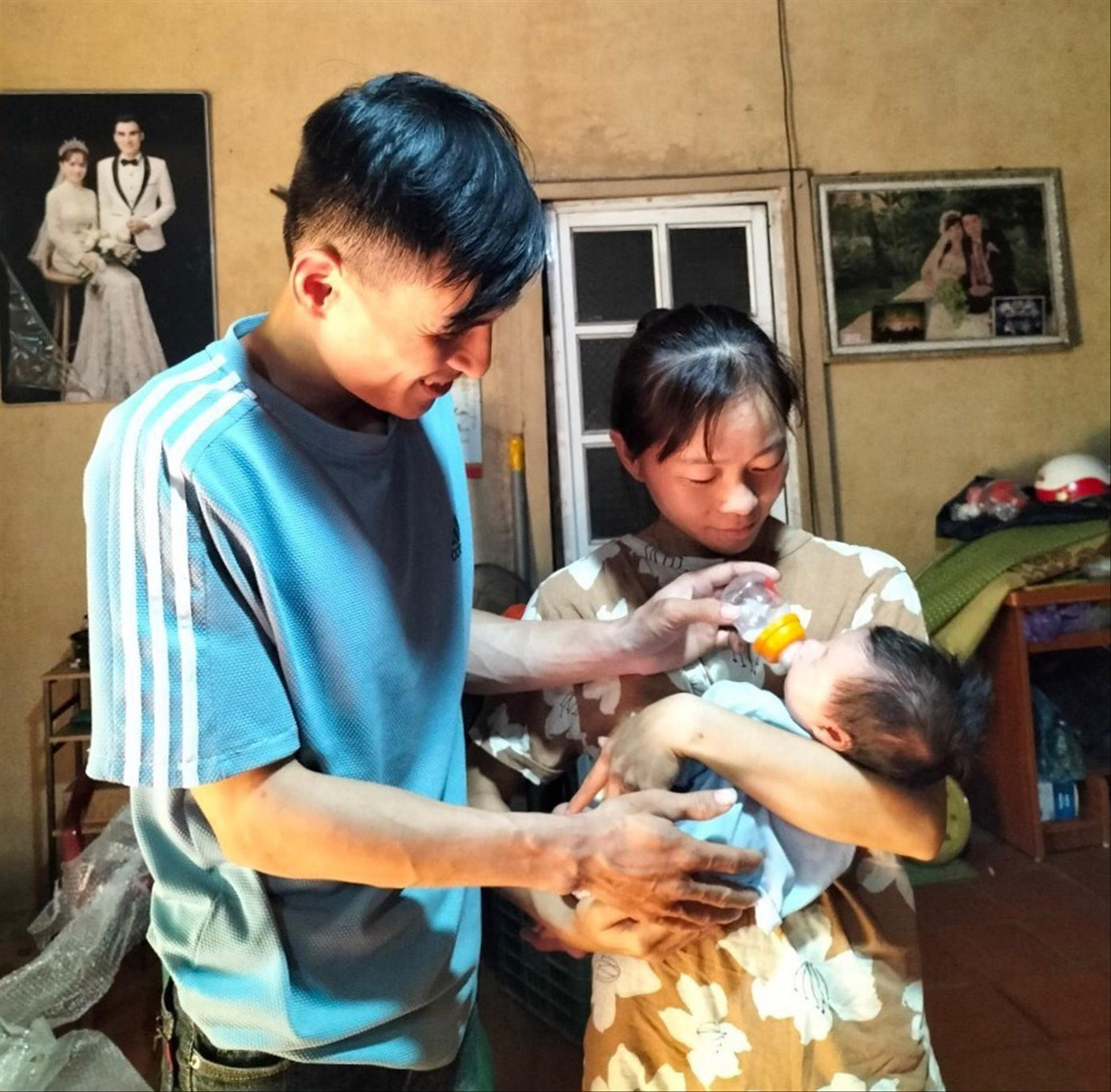Vợ chồng anh Quyền chăm sóc cháu bé Ảnh: Duy Chiến