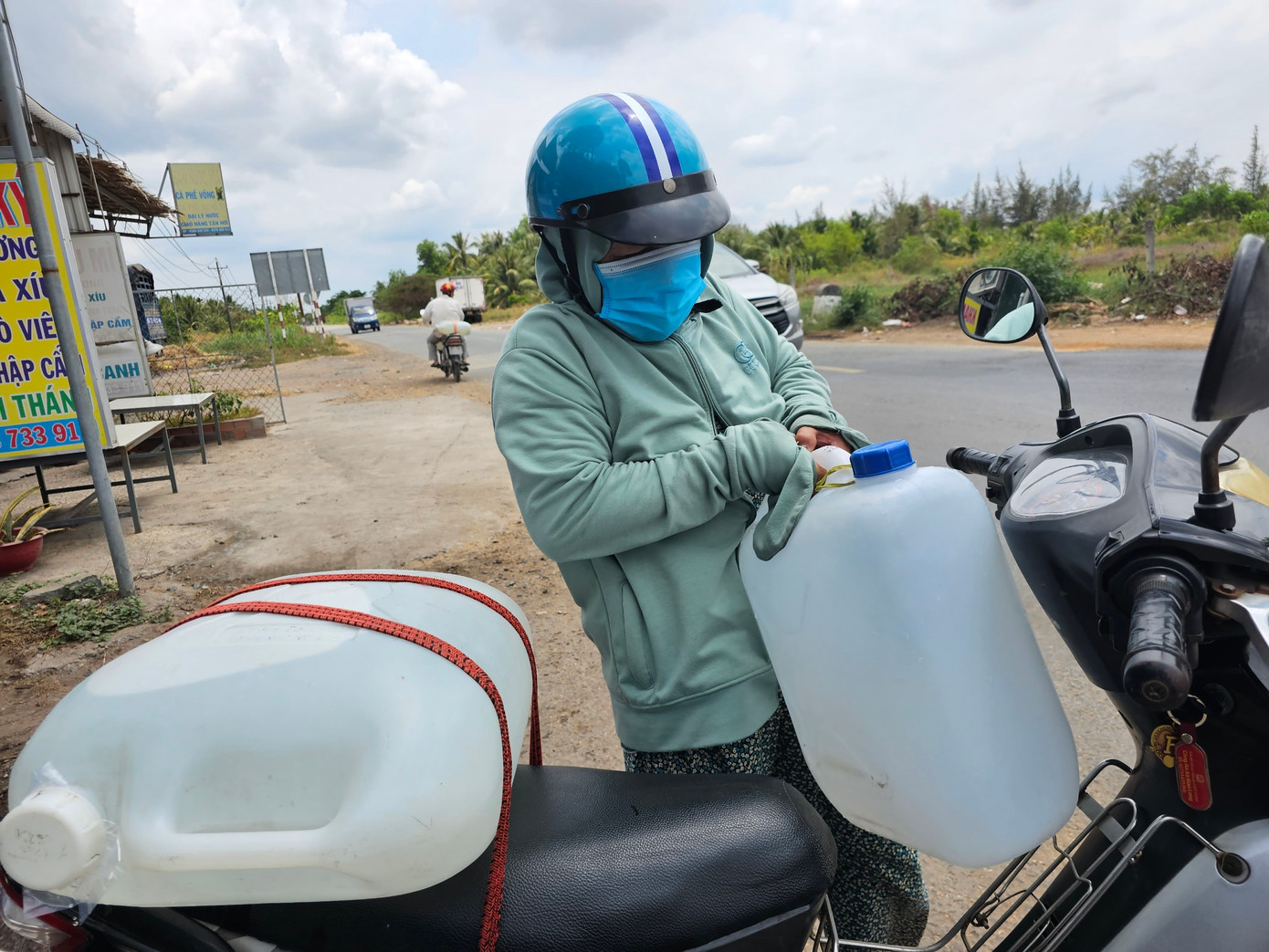 Bà Đặng Thị Kim Chi ở ấp Long Hội, xã Giao Long (Châu Thành, Bến Tre) chở nước ngọt giúp cho người dân trong mùa hạn mặn. Ảnh: HÒA HỘI