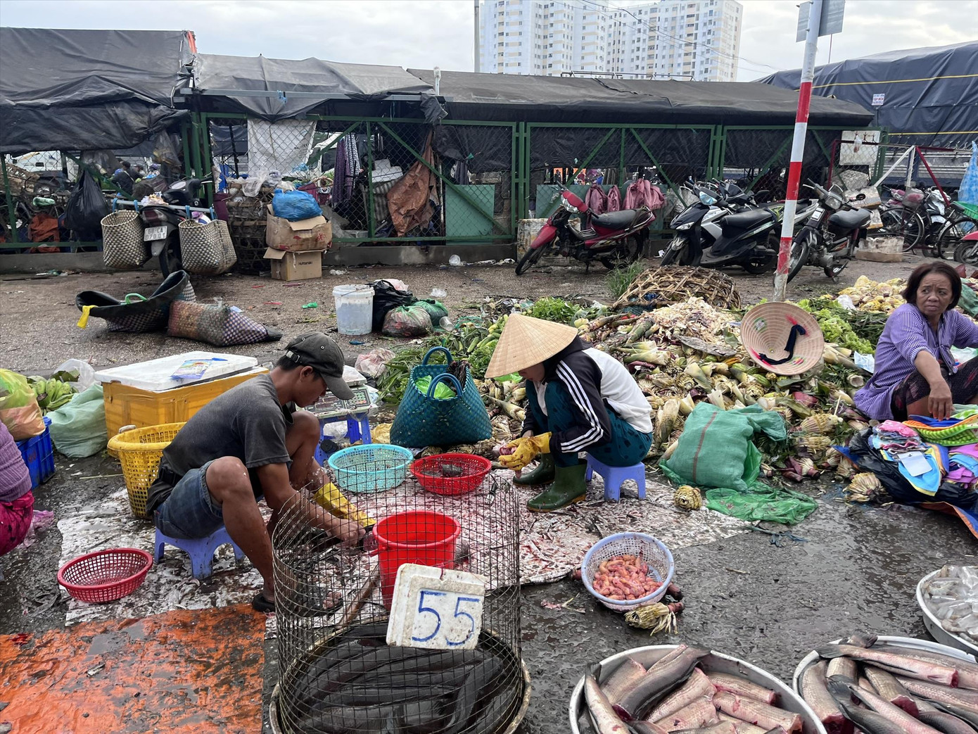 Tiểu thương sơ chế cá trực tiếp trên tấm bạt, bên cạnh là đống rác. Ảnh: Nhàn Lê. Tiểu thương sơ chế cá trực tiếp trên tấm bạt, bên cạnh là đống rác. Ảnh: Nhàn Lê.