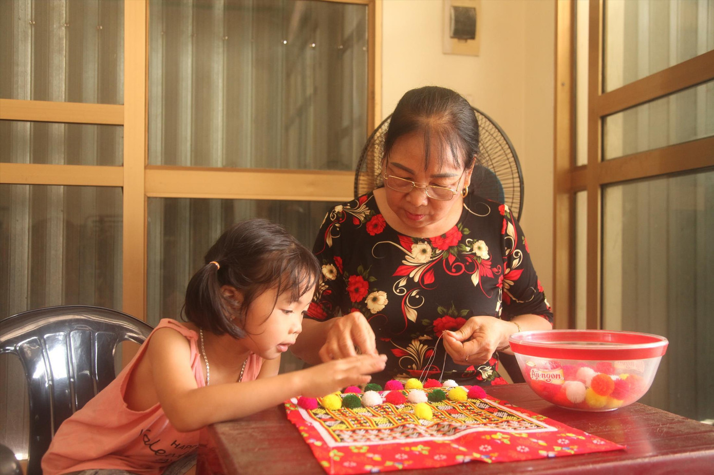 Bà Bình truyền dạy thêu trang phục truyền thống cho các cháu trong gia đình