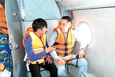 Phóng viên Nguyễn Minh của báo Tiền Phong (bên trái) trò chuyện với Trung úy Đỗ Trung Kiên trên chuyến bay của Trung đoàn 916 đi cứu trợ đồng bào tỉnh Cao Bằng, ngày 12/9/2024. ẢNH: CTV