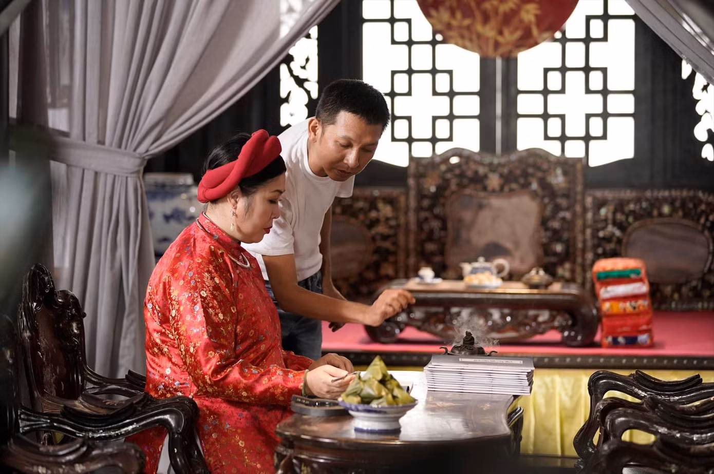 Đạo diễn Huỳnh Tuấn Anh và NSND Hồng Vân tập luyện cảnh mài mực, viết bút lông trong phim Phượng khấu Ảnh: ĐLPCC