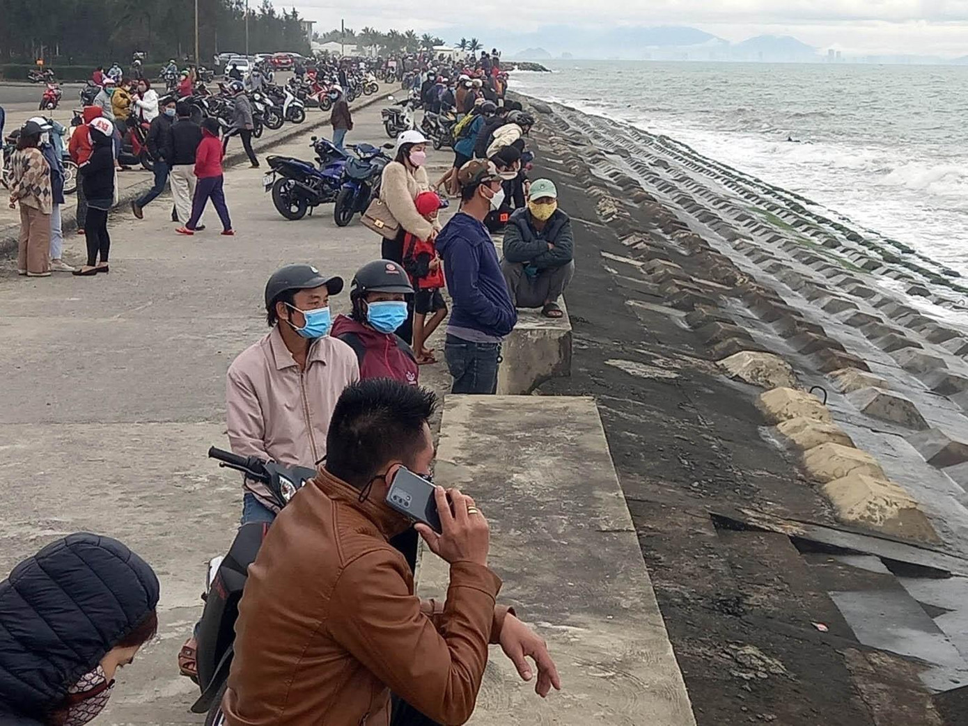 Người dân theo dõi lực lượng chức năng tìm kiếm nạn nhân mất tích tại biển Cửa Đại Người dân theo dõi lực lượng chức năng tìm kiếm nạn nhân mất tích tại biển Cửa Đại