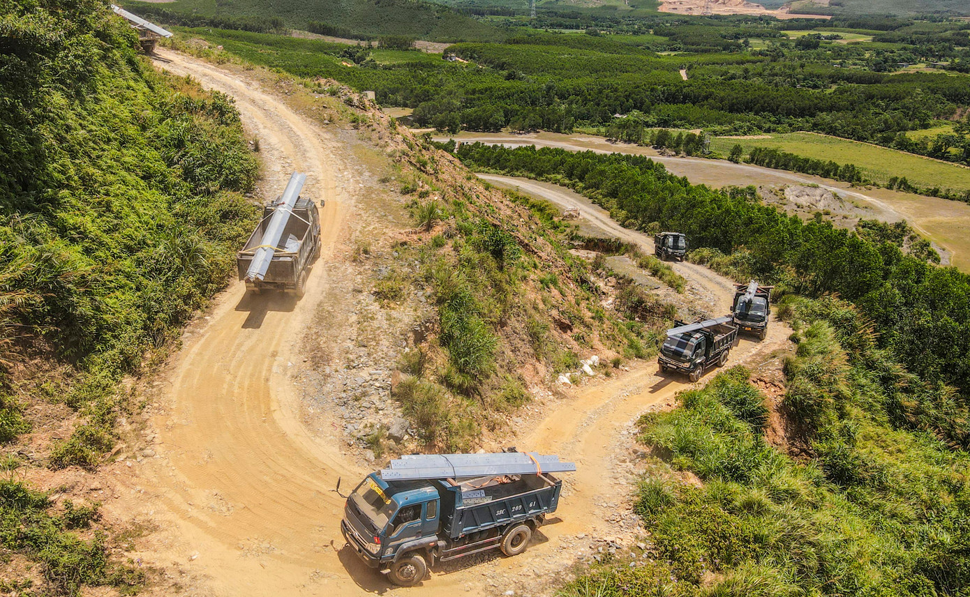 Đoàn xe chở thép vượt đồi cao đưa thiết bị đến công trường