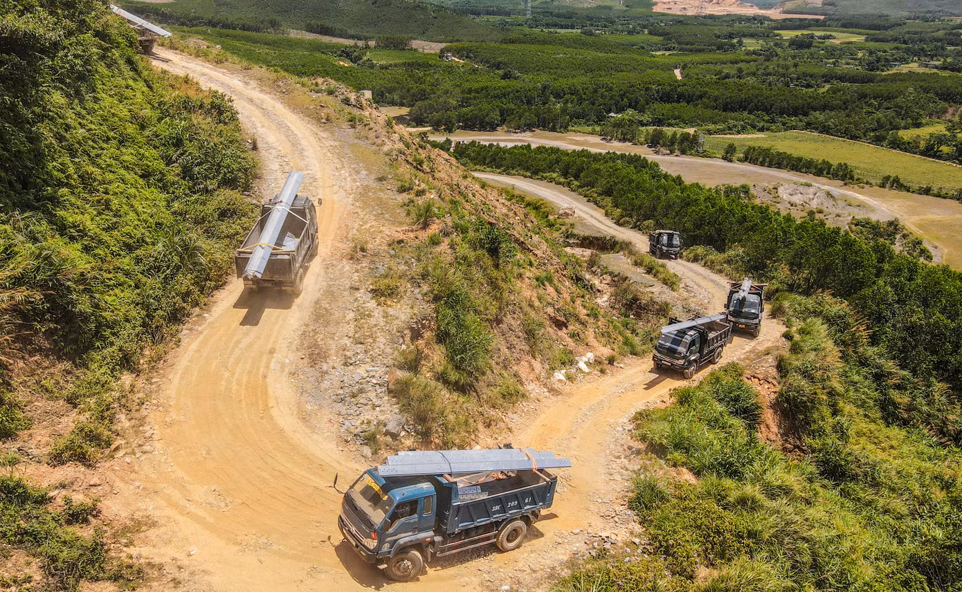 Đoàn xe chở thép vượt đồi cao đưa thiết bị đến công trường