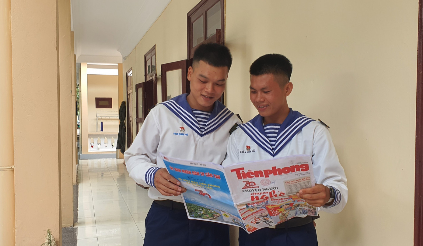 Chiến sỹ Phạm Quang Phú (bìa trái), Trần Sinh Sắc đọc báo Tiền Phong