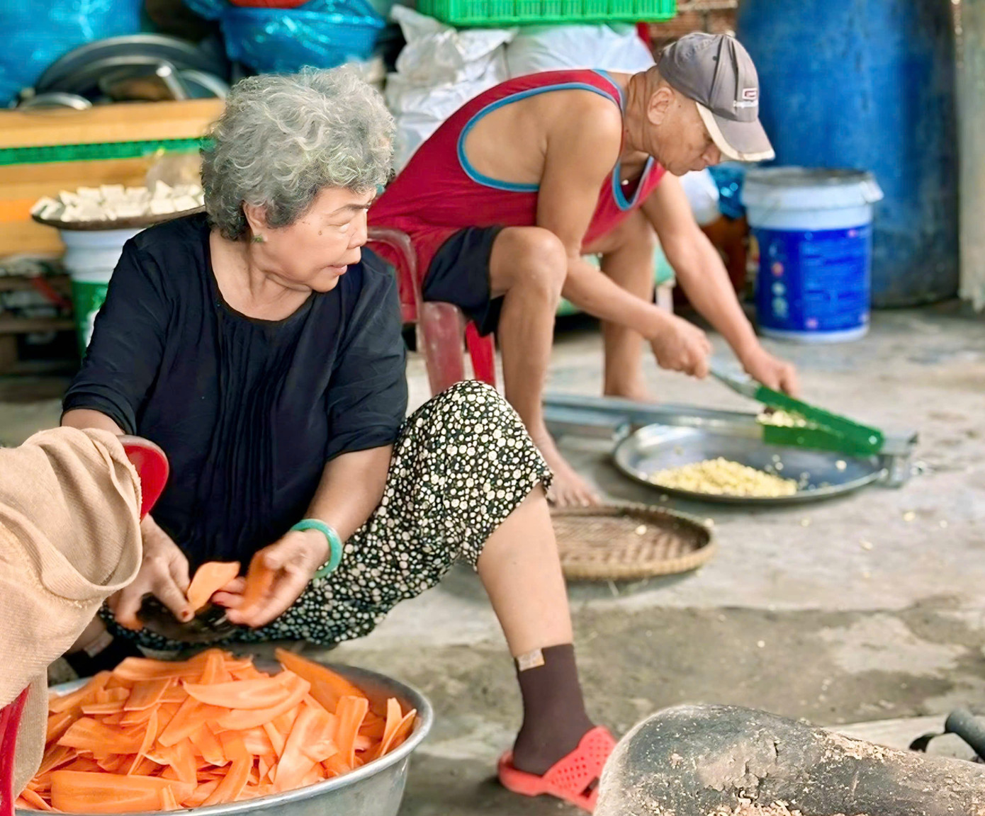 Ông Thành cùng vợ chuẩn bị nguyên liệu để nấu cháo từ thiện.