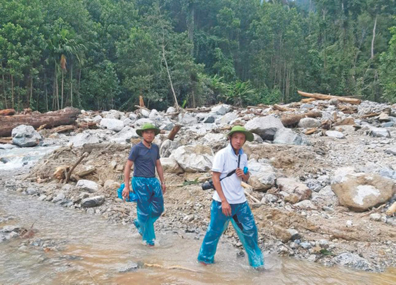 Phóng viên Nguyễn Thành (đi trước) và Cảnh Huệ đi vào vùng sạt lở ở Trà Leng Ảnh: Viết Lam