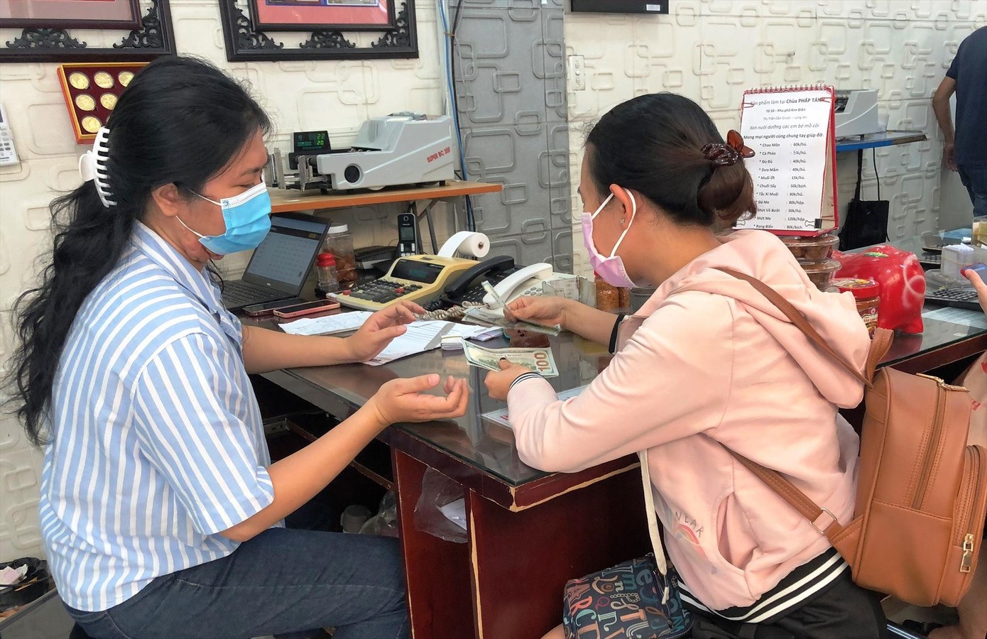 Người dân mua bán USD (chụp tại một điểm thu đổi ngoại tệ ở quận 1, TPHCM trưa 28/2). Ảnh: U.P