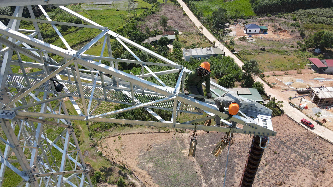 Kỹ sư, công nhân leo trèo trên cột cao để néo dây cáp dẫn