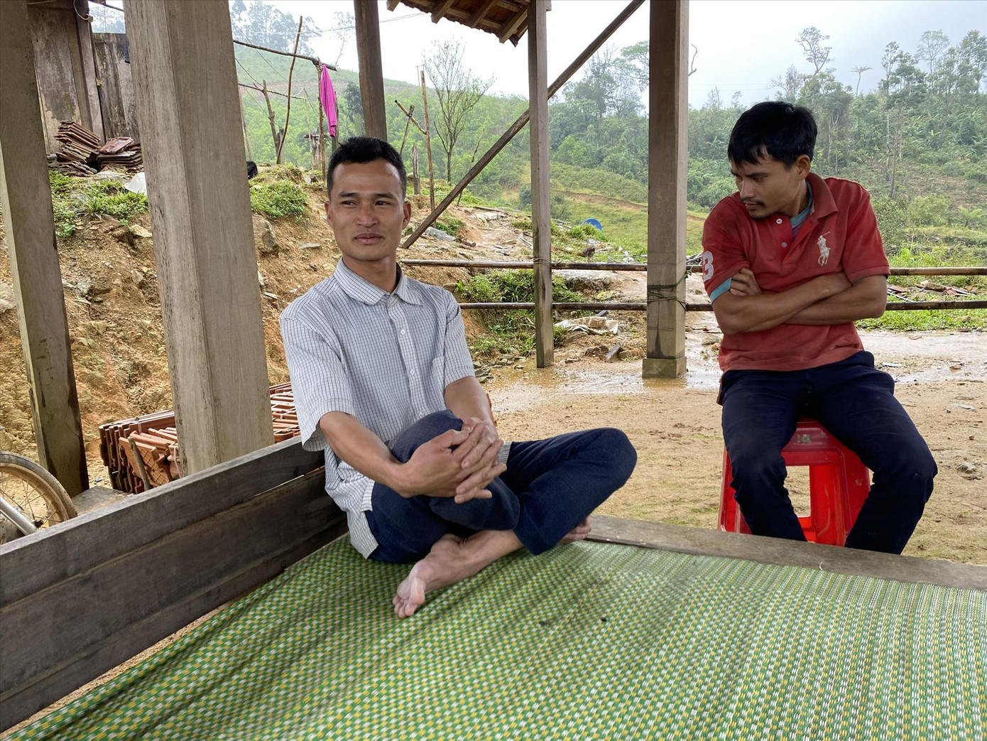 Hồ Văn Liên (trái) - người chuyên hỗ trợ đỡ đẻ tại làng và Hồ Văn Hải chia sẻ về cuộc sống ở thôn Quế Hồ Văn Liên (trái) - người chuyên hỗ trợ đỡ đẻ tại làng và Hồ Văn Hải chia sẻ về cuộc sống ở thôn Quế