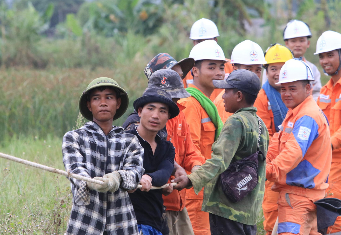 Anh Hoàng Văn Tiến (SN 1993, trú tỉnh Hòa Bình - áo đen) đang cùng đồng nghiệp kéo dây, dựng cột điện