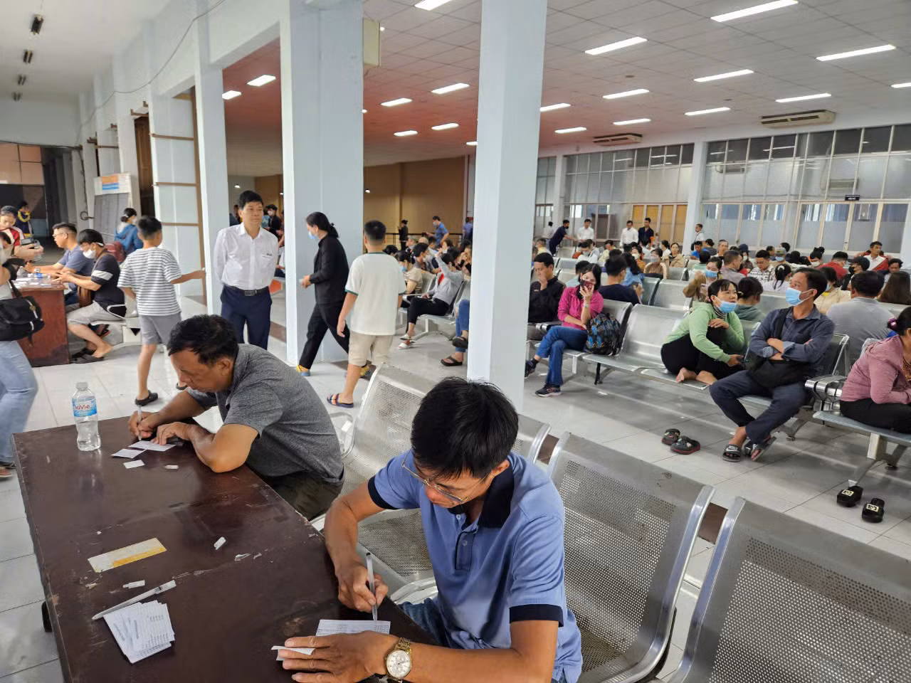 Người dân điền phiếu thông tin trước khi mua vé.