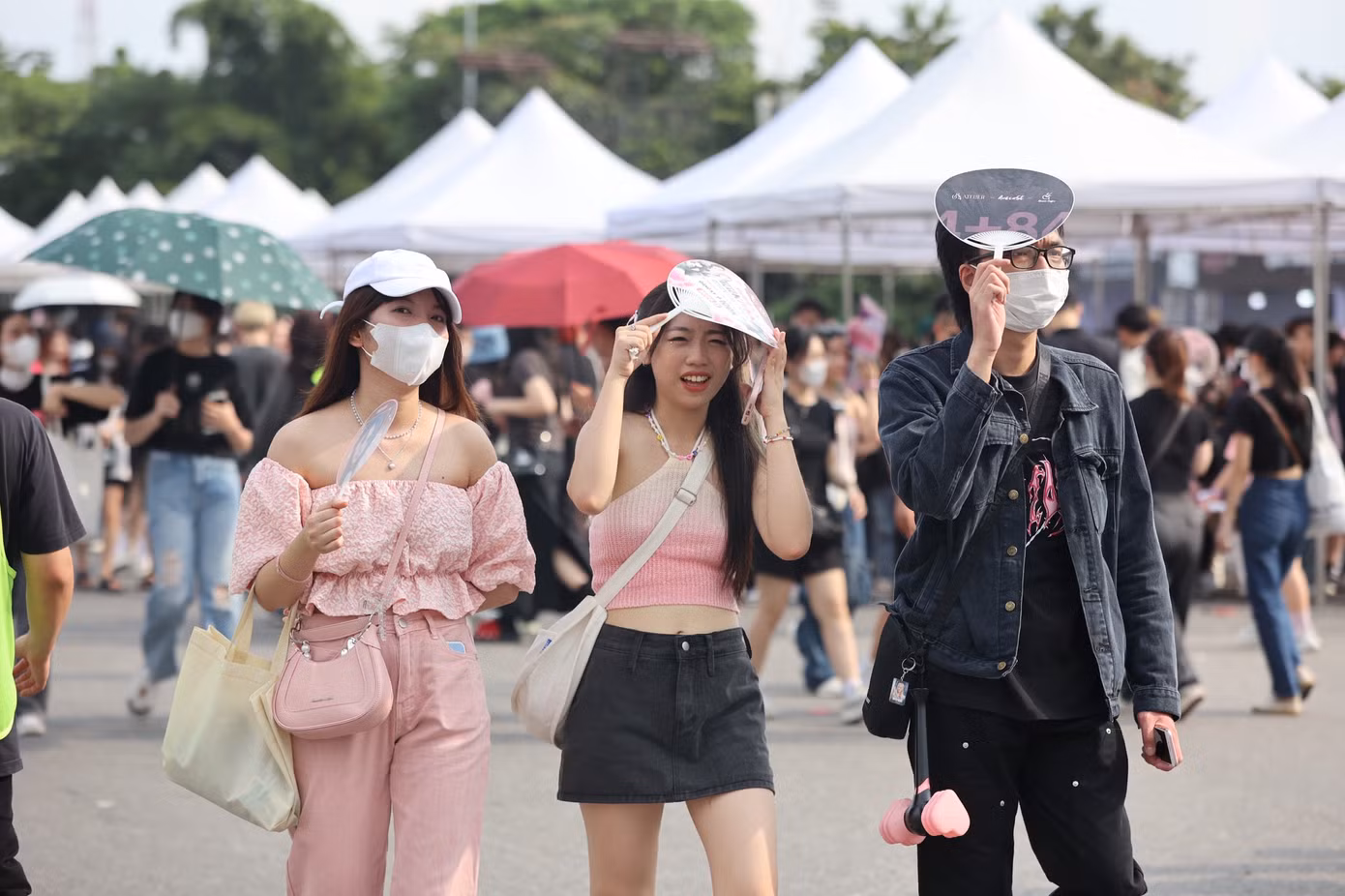 Fan nữ diện trang phục theo phong cách thần tượng, mang theo vật phẩm cổ vũ hào hứng chờ đến giờ diễn.
