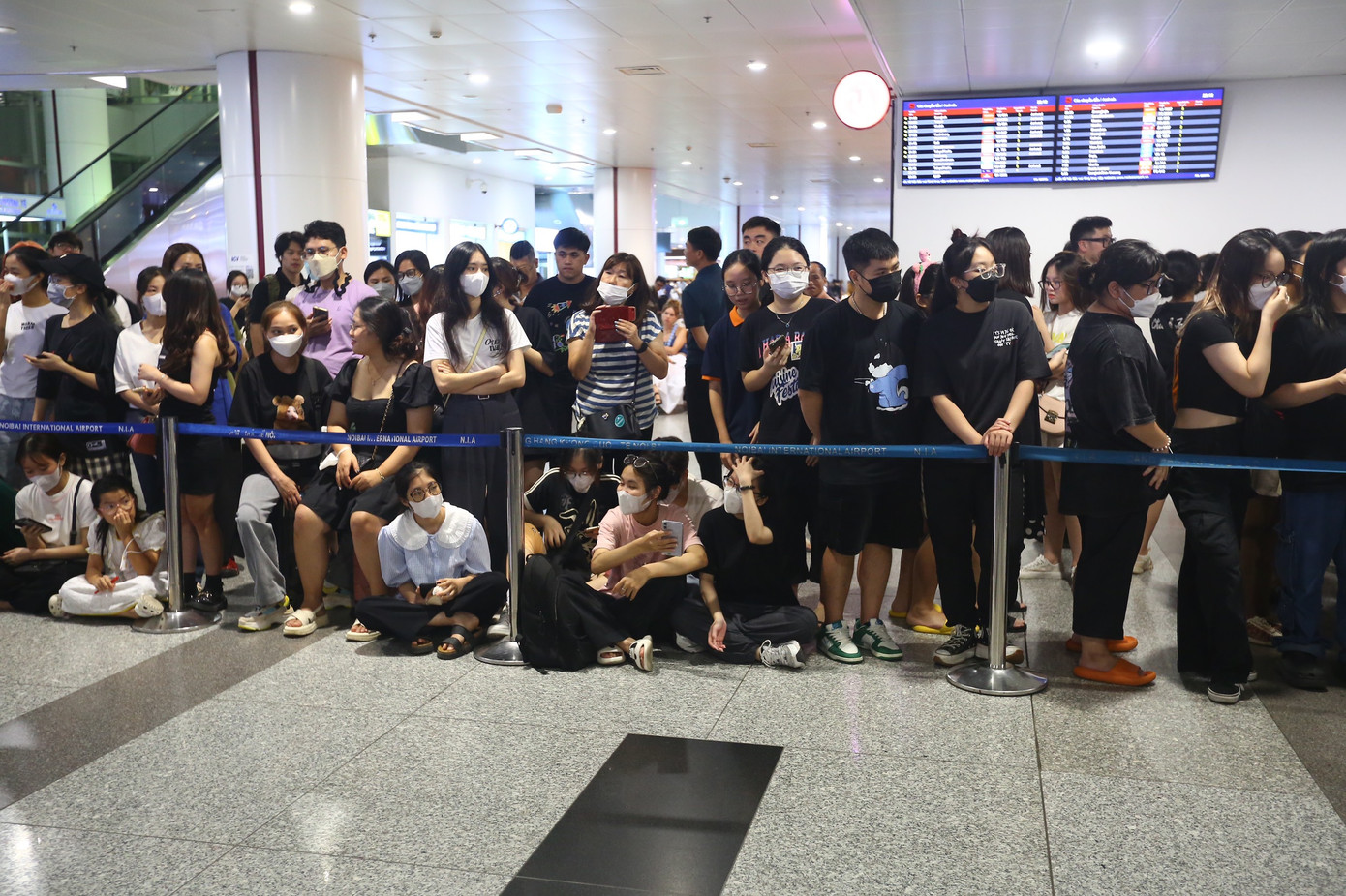 Một số fan bắt đầu thấm mệt, ngồi xuống sàn sảnh đến, nhưng ánh mắt vẫn chăm chú nhìn về phía cổng ra.