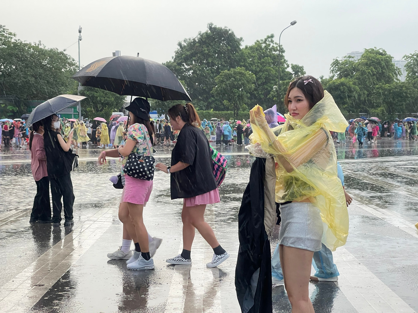 Người hâm mộ chật vật dưới mưa. Dù mặc áo mưa và che ô, họ không tránh khỏi bị ướt. Người hâm mộ chật vật dưới mưa. Dù mặc áo mưa và che ô, họ không tránh khỏi bị ướt.