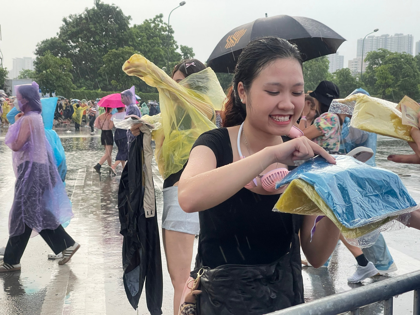 Một fan bỏ tiền mua áo mưa tiện lợi. Dù ướt gần hết người, cô vẫn cười tươi vui vẻ. Một fan bỏ tiền mua áo mưa tiện lợi. Dù ướt gần hết người, cô vẫn cười tươi vui vẻ.