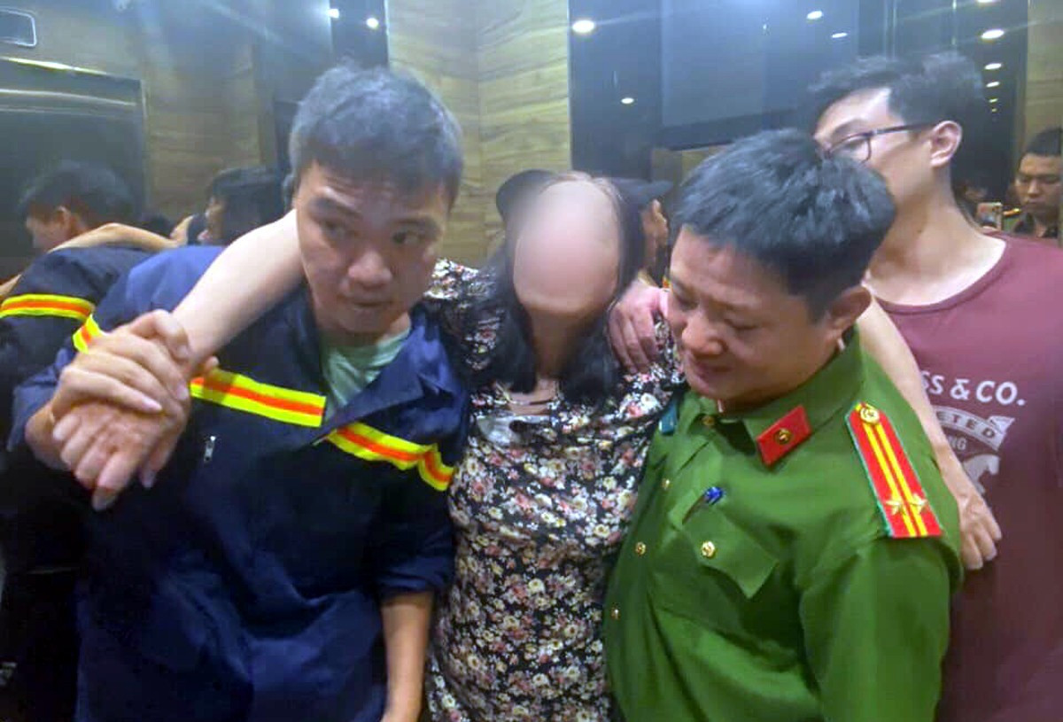 Các chiến sĩ công an đưa người phụ nữ xuống nơi an toàn. Ảnh: CACC. Các chiến sĩ công an đưa người phụ nữ xuống nơi an toàn. Ảnh: CACC.