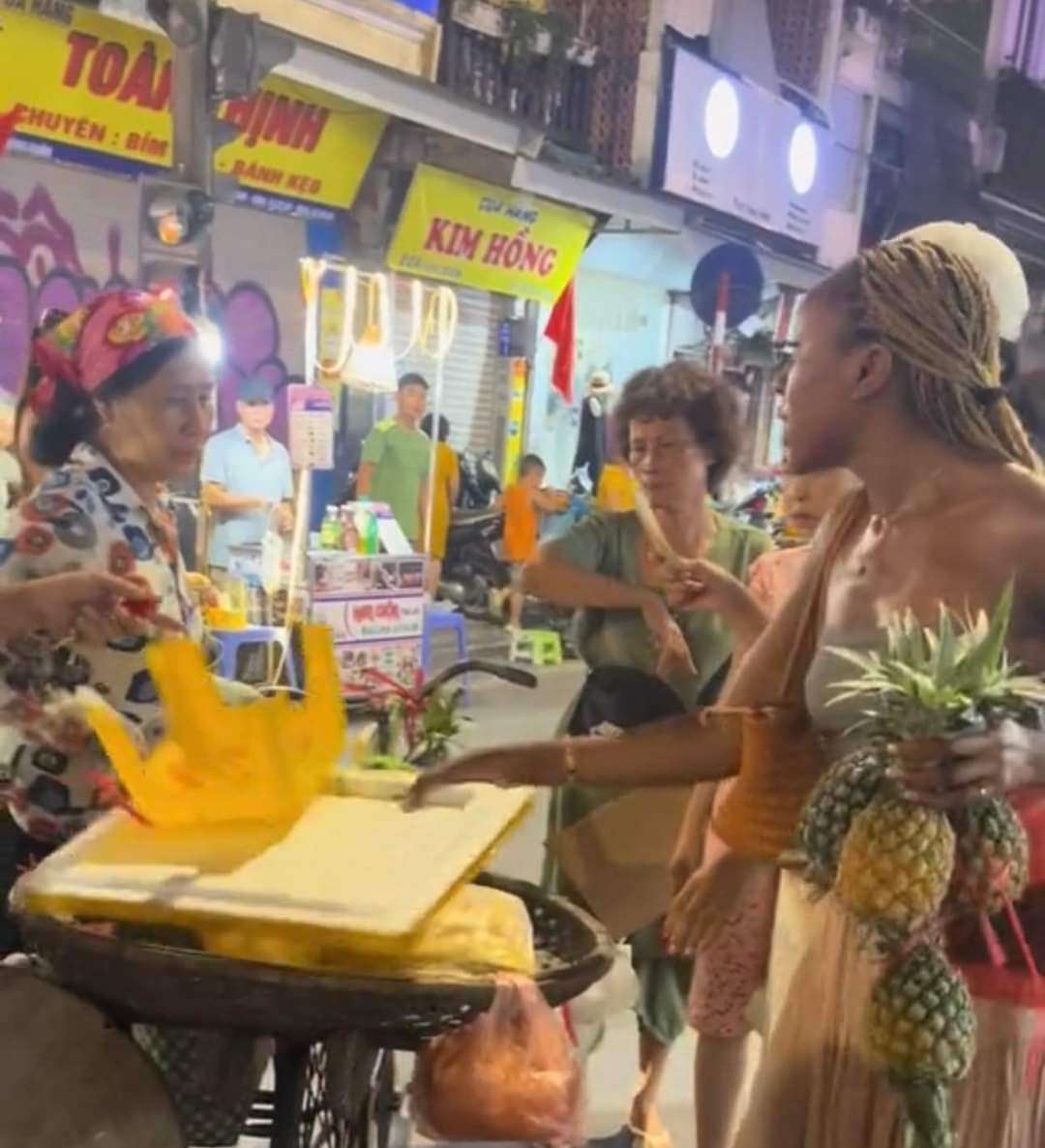 Hình ảnh người bán hàng rong bán 3 quả dứa với giá 500.000 đồng cho 2 du khách nước ngoài (ảnh cắt từ clip) Hình ảnh người bán hàng rong bán 3 quả dứa với giá 500.000 đồng cho 2 du khách nước ngoài (ảnh cắt từ clip)
