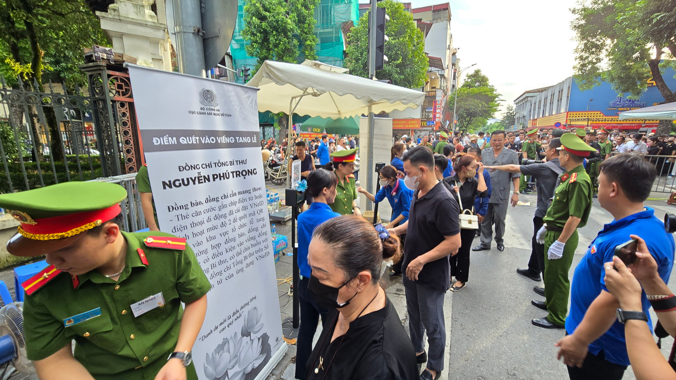 Lực lượng công an, đoàn viên, thanh niên hỗ trợ người dân quét mã QR trước khi vào Nhà tang lễ Quốc gia viếng Tổng Bí thư Nguyễn Phú Trọng.