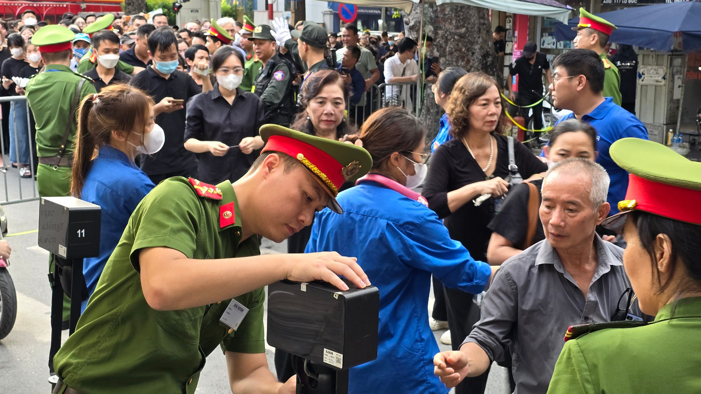 Lực lượng công an, đoàn viên, thanh niên hỗ trợ người dân quét mã QR trước khi vào Nhà tang lễ Quốc gia viếng Tổng Bí thư Nguyễn Phú Trọng.