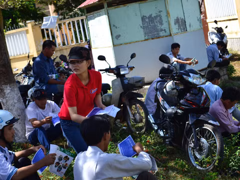 Nhân viên các Trung tâm tuyển sinh tranh thủ phát tờ rơi tuyển sinh. ảnh Việt Hương