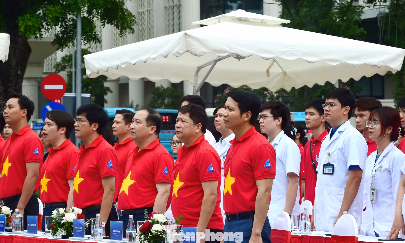 Các đại biểu, thầy thuốc trẻ tham dự chương trình ra quân thực hiện nghi thức chào cờ. Ảnh: Xuân Tùng