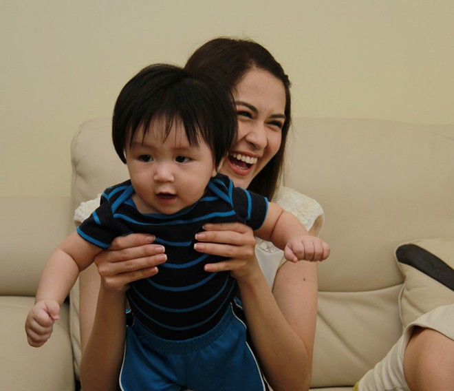 Người đẹp cười rạng rỡ khi bế em bé chụp hình lưu niệm