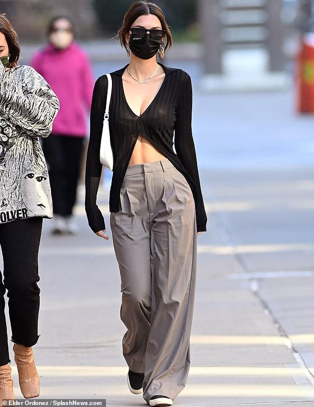 Emily Ratajkowsi thả dáng đẹp như fashionista trên phố với chiếc áo len mỏng cắt xẻ gợi cảm, quần vải ống rộng mềm mại khiến cho nàng mẫu dù đeo khẩu trang nhưng vẫn cho thấy sắc vóc gợi cảm, xinh đẹp hơn người.