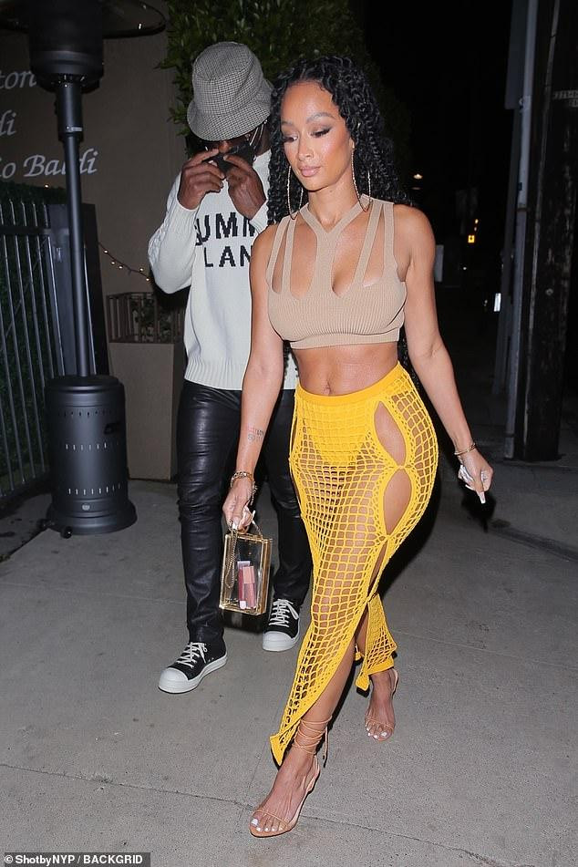 Draya Michele (SN 1985) gây chú ý trên phố với trang sexy hết nấc. Cô mặc chiếc crop top cắt xẻ phần ngực và chiếc váy lưới màu vàng lộ nguyên nội y.