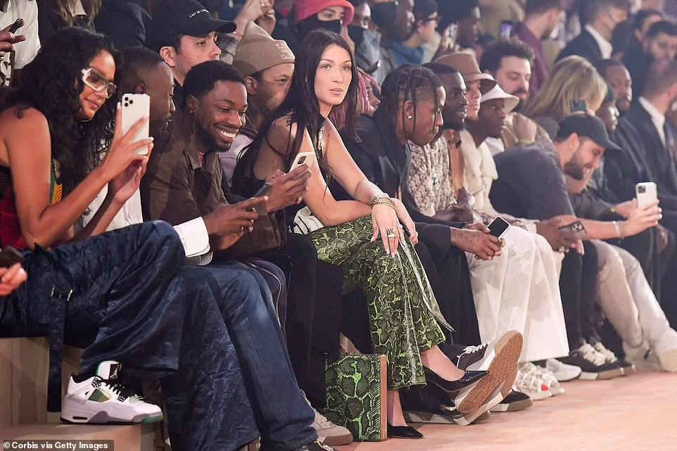 Người đẹp ngồi cạnh rapper Travis Scott (bên trái Bella Hadid) chiêm ngưỡng các người mẫu nam trình diễn. Được biết, bộ sưu tập dành cho nam giới này do Travis Scott và Kim Jones - Giám đốc sáng tạo dòng thời trang nam của Dior hợp tác thiết kế.